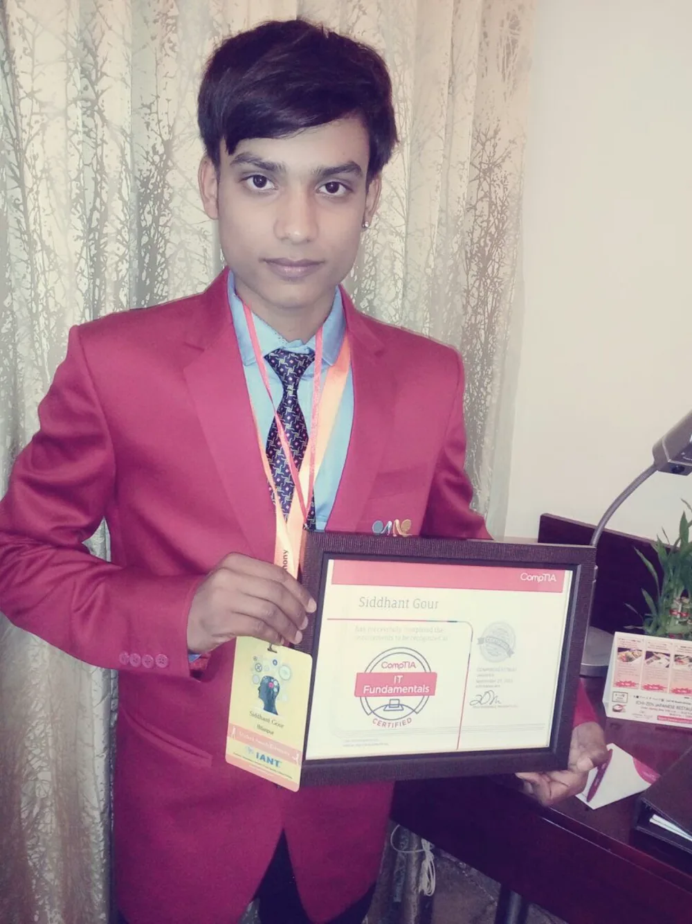 Siddhant Gour in a maroon IANT blazer holding his award certificate, 2016